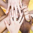 Top view of multiracial stacking hands – International friendship concept with multiethnic people representing peace and unity against racism – Multi racial love and integration between diversity Jak wykorzystać różnice kulturowe, aby pokazać gościom gościnność?